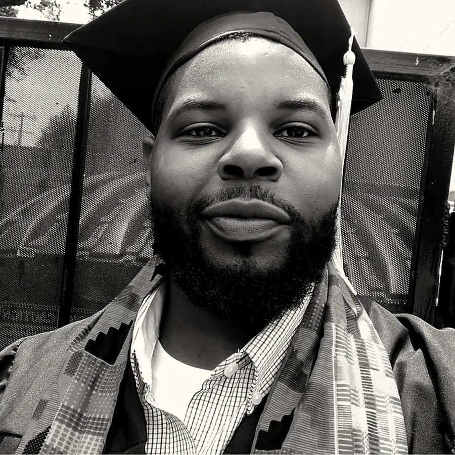 Matthew Scott in cap and gown with a kente stole